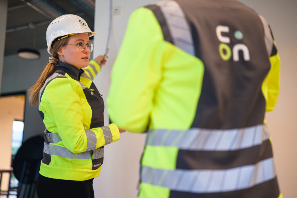 Zwei Mitarbeitende in Warnjacken mit CLARY.ON-Logo im Rohbau